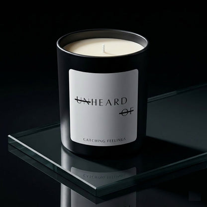 UNHEARD OF Catching Feelings luxury candle, matte black jar with minimalist label, 8oz hand-poured coconut wax, cardamom and vetiver scent.