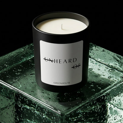 UNHEARD OF Greenhouse Jalapeno luxury candle, matte black jar with minimalist white label, 8oz hand-poured coconut wax, spicy organic green scent, high-end editorial product photography.
