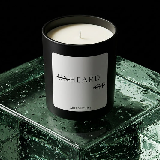 UNHEARD OF Greenhouse Jalapeno luxury candle, matte black jar with minimalist white label, 8oz hand-poured coconut wax, spicy organic green scent, high-end editorial product photography.