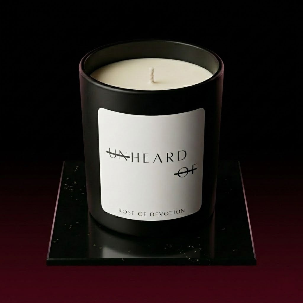 UNHEARD OF Rose of Devotion luxury rose and oud candle, matte black jar with minimalist label, 8oz hand-poured coconut wax, labdanum and honey scent profile.