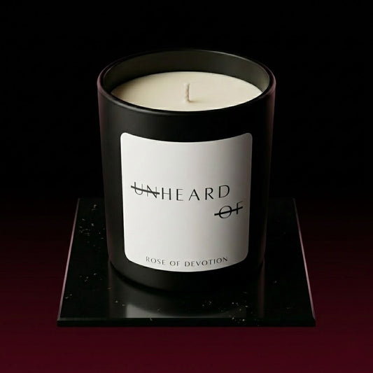 UNHEARD OF Rose of Devotion luxury rose and oud candle, matte black jar with minimalist label, 8oz hand-poured coconut wax, labdanum and honey scent profile.